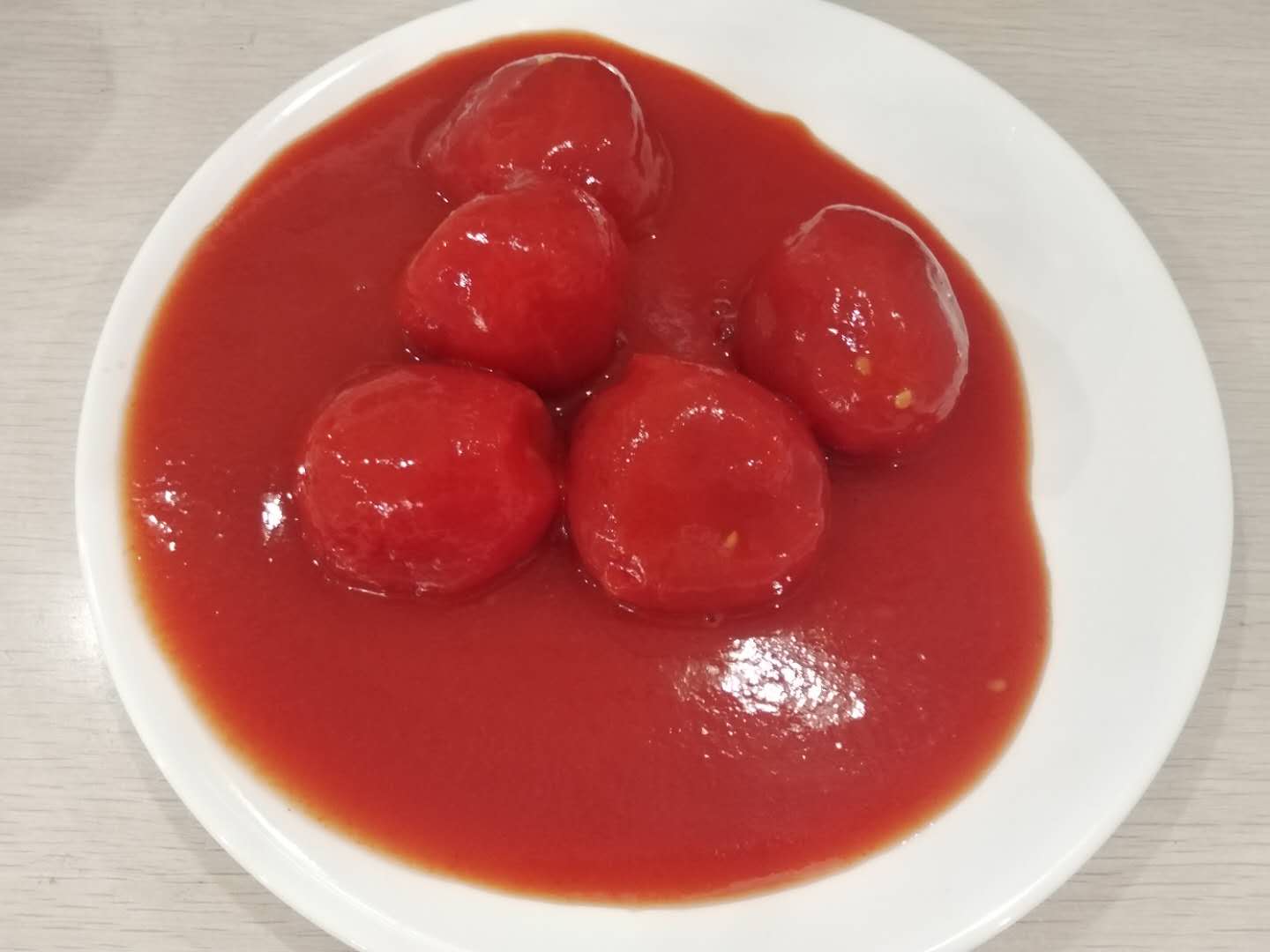 Tomat-tomat kupas utuh dengan jus tomat konsentrasi tinggi